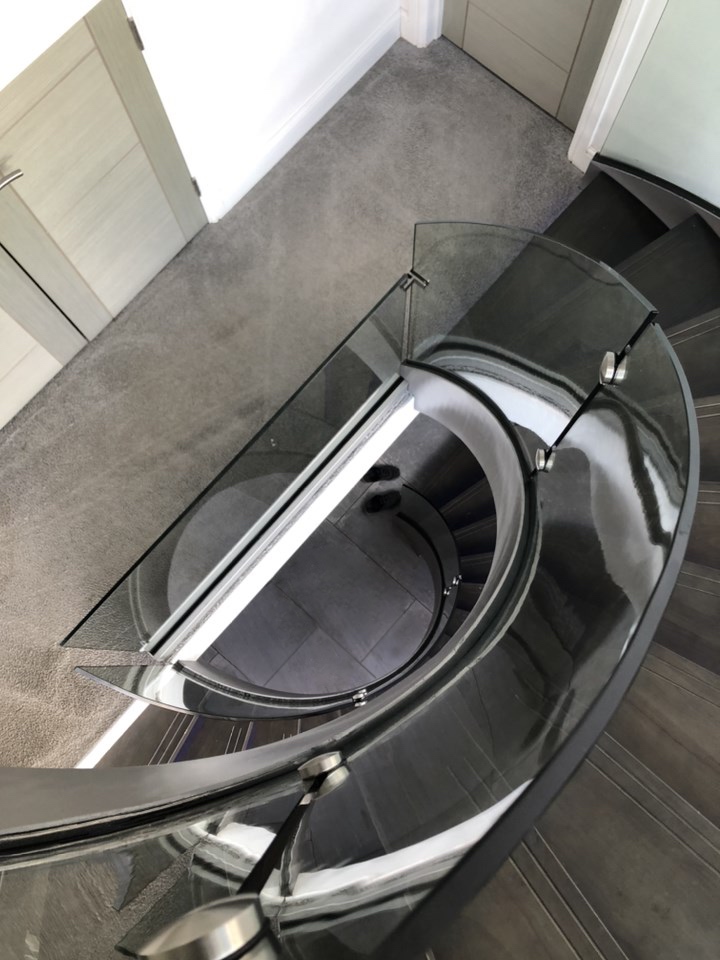 three flights of helical staircase with curved glass balustrade