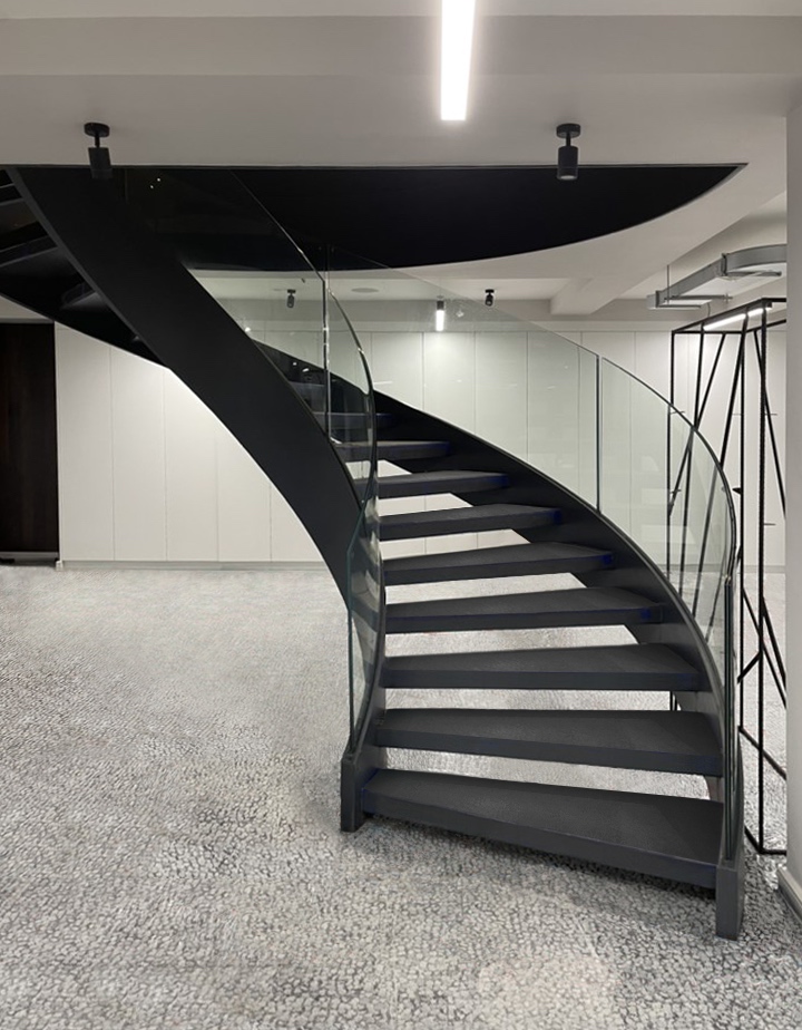 Metal spiral staircase with curved glass balustrades