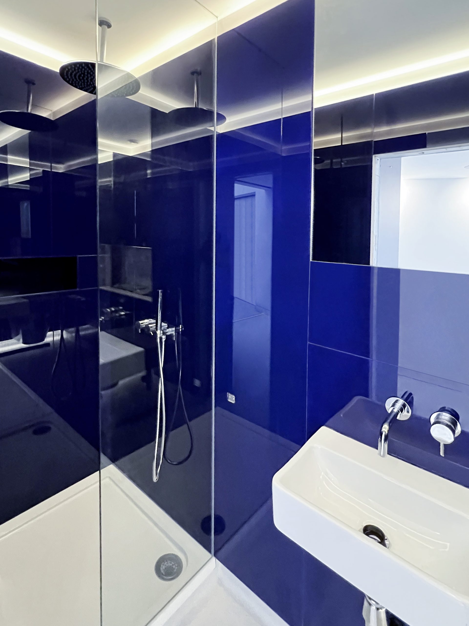 glass shower enclosure with blue bathroom tiles
