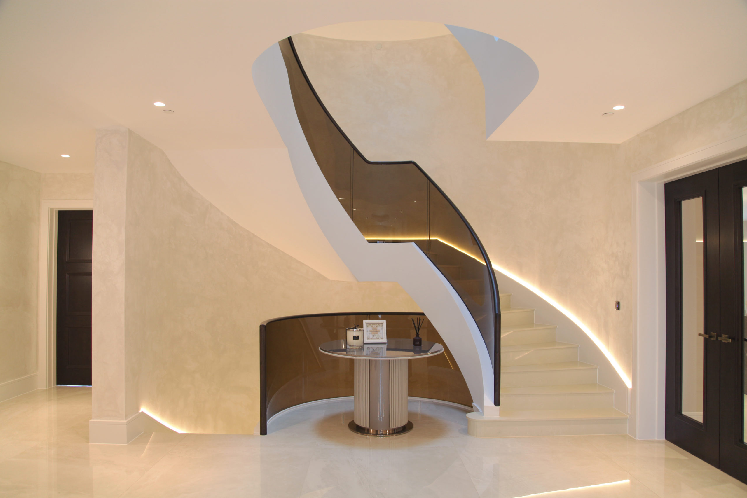 White Helical staircase complemented with tinted glass balustrade