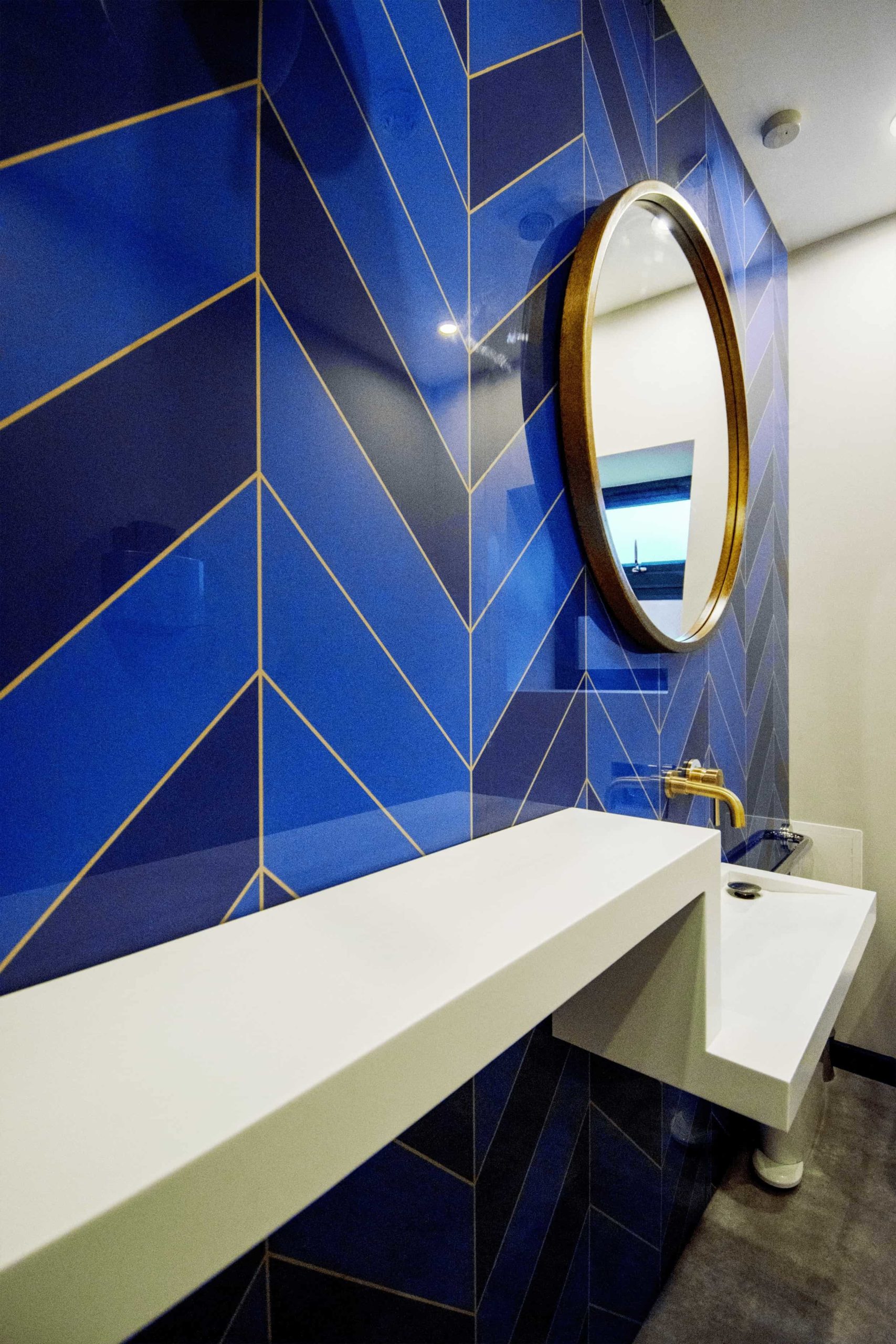 Bathroom wall cladded with custom blue tiles
