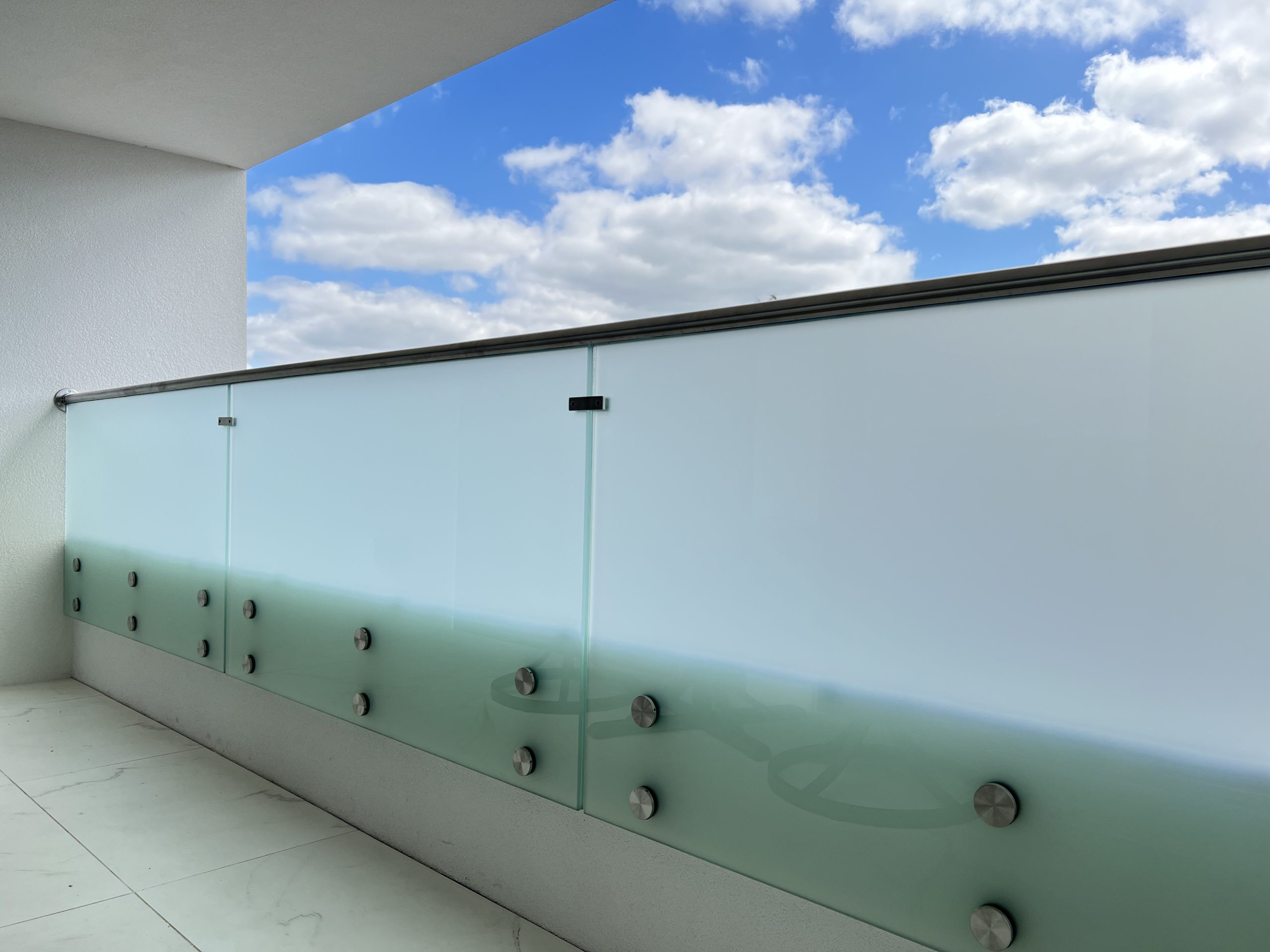 Frosty glass balustrade with steel handrail on top