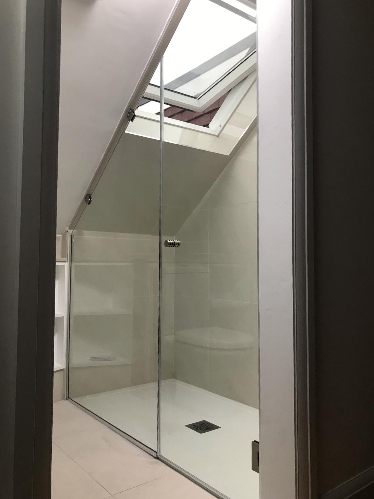 Glass shower enclosure in the attic room