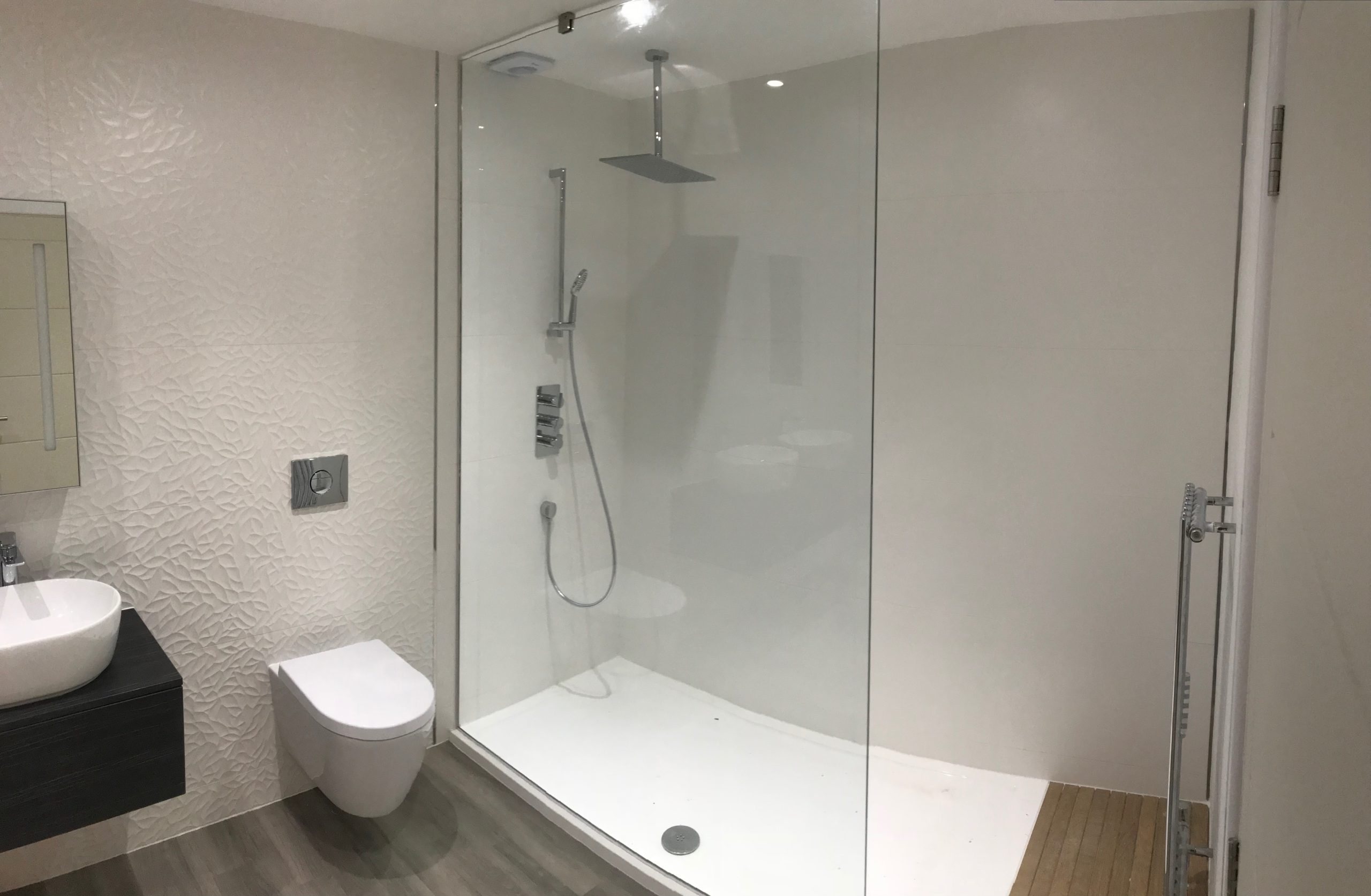 Modern bathroom having glass shower enclosure with white tray
