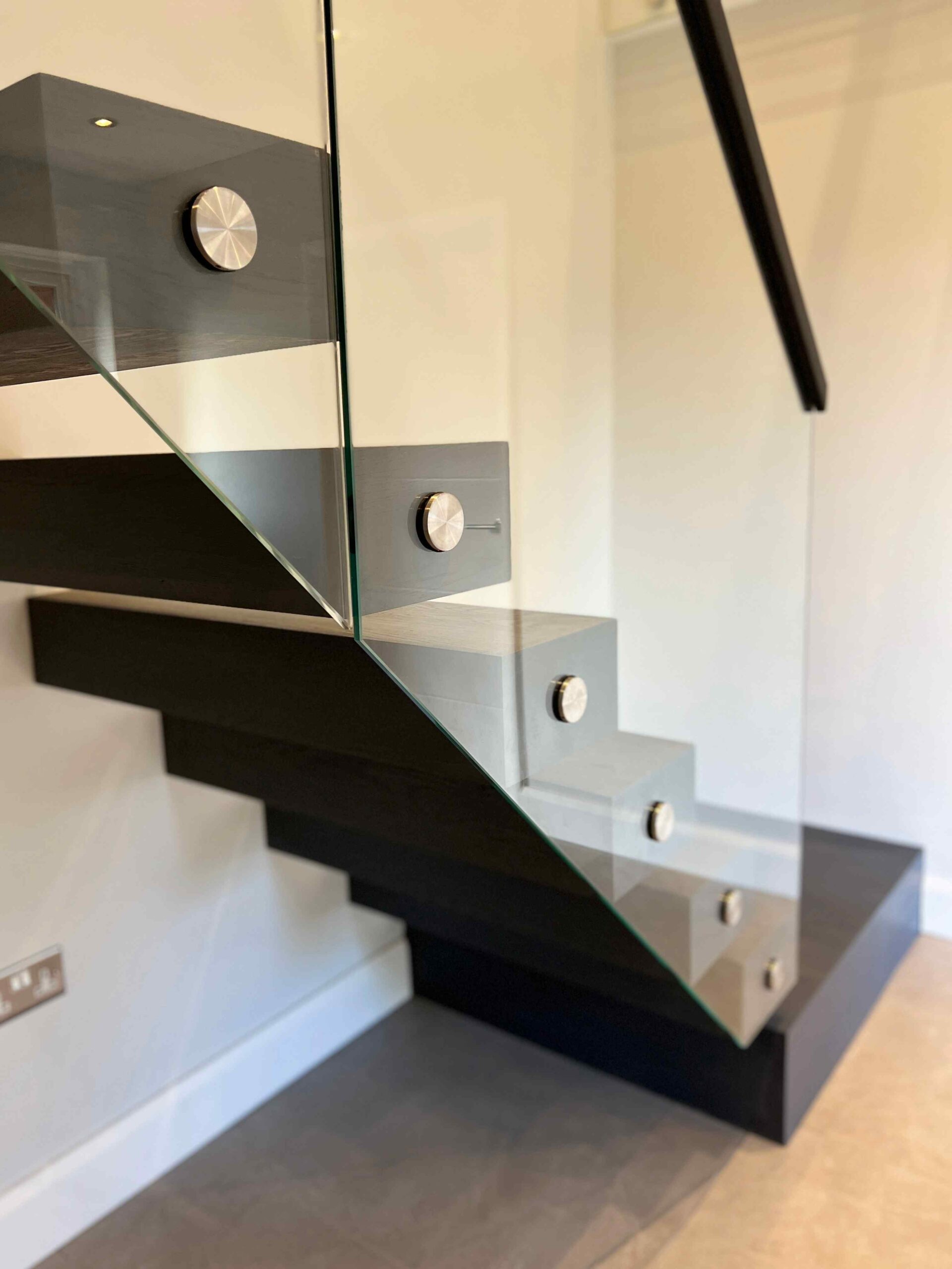  Floating staircase complemented with glass balustrade and black oak stair treads